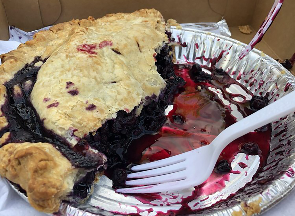 blueberry pie in baking pan with slices removed