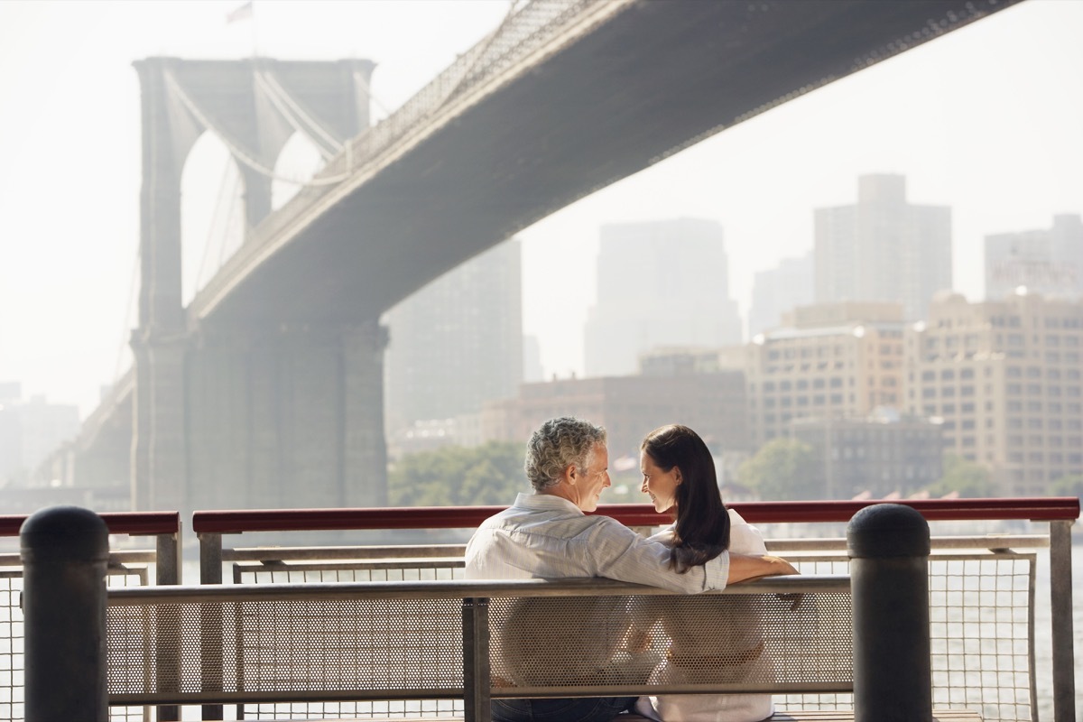 Couple sitting by bridge on a bench