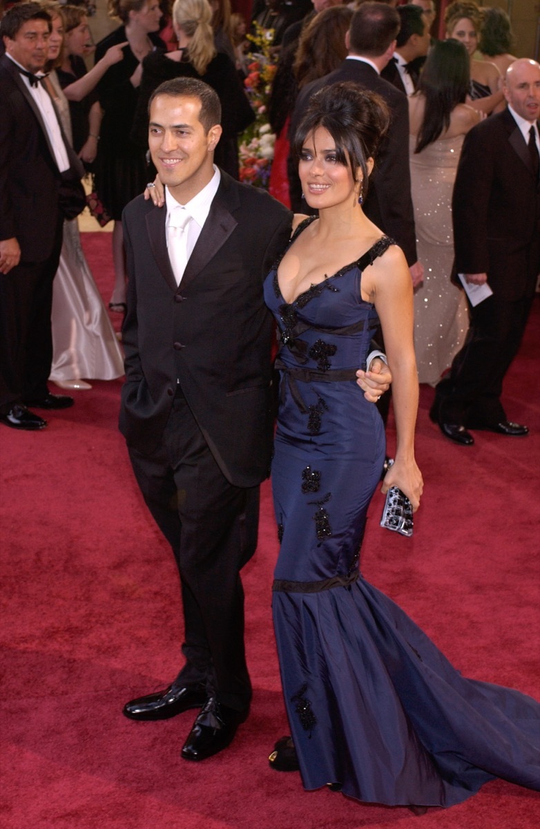 salma hayek in a blue gown standing next to her brother sammy on a red carpet