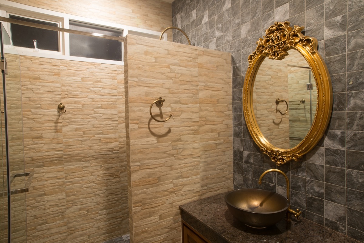 ornate gold mirror hung in bathroom