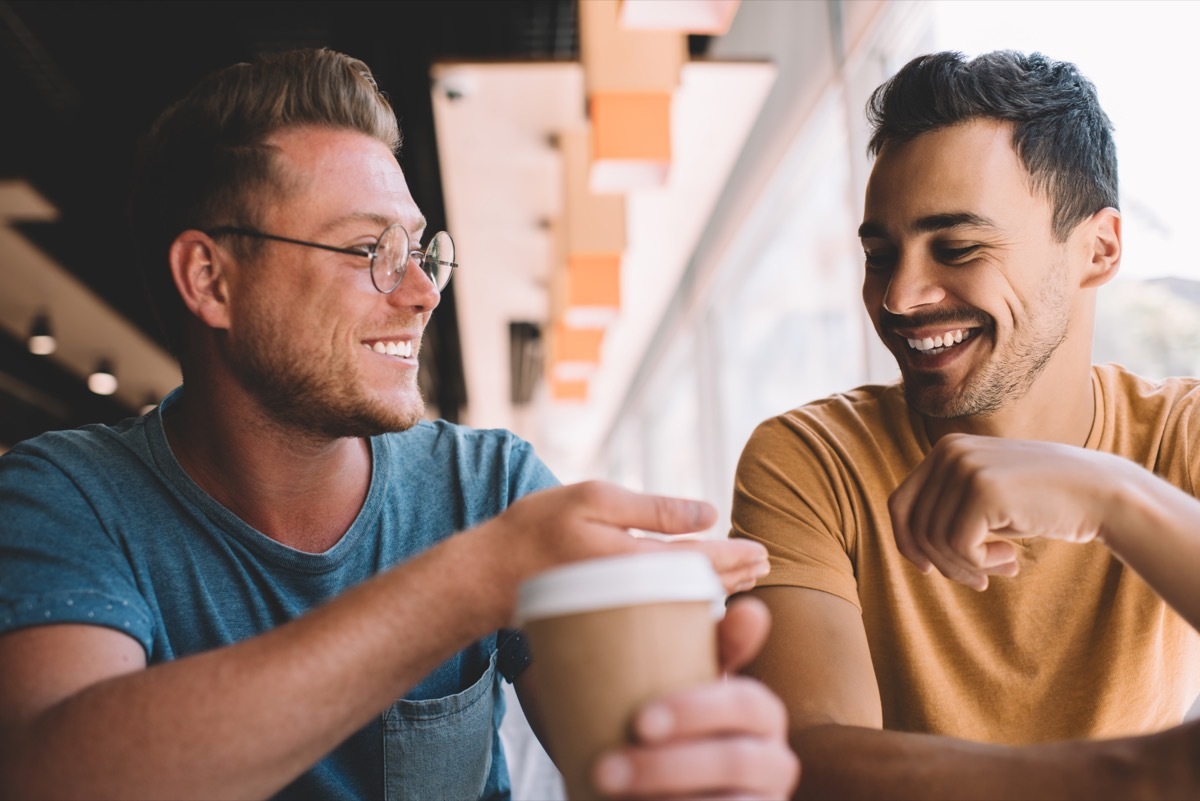 two men laughing and talking at the cafe
