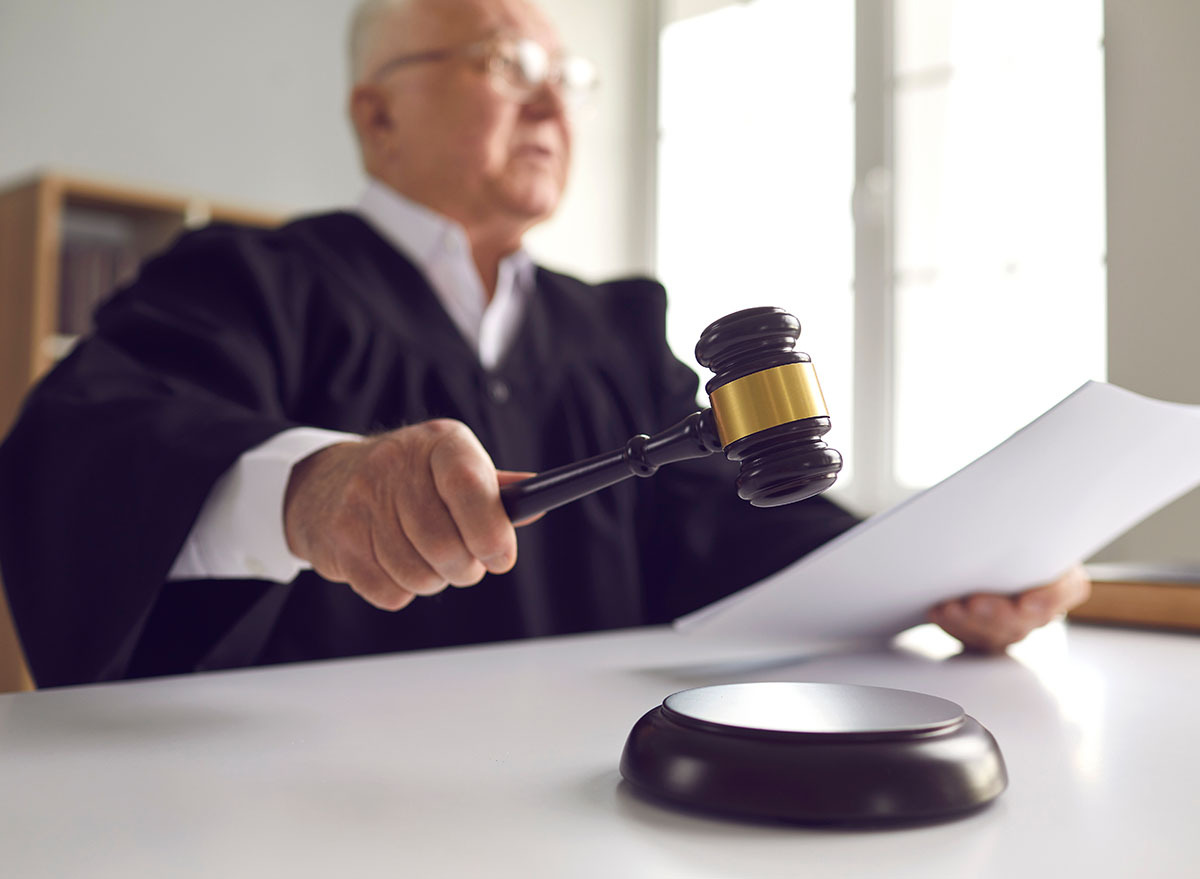 A judge using a gavel while holding a document