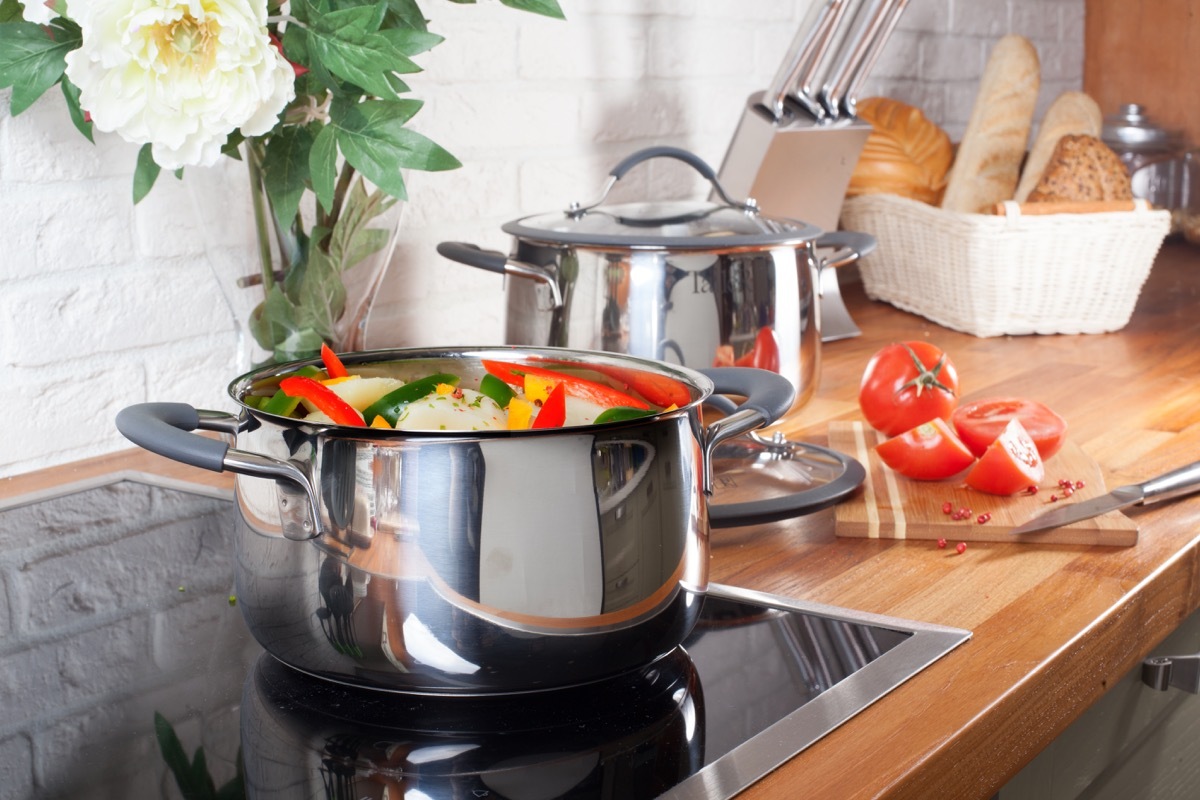 Induction cooking stove with pot of vegetables