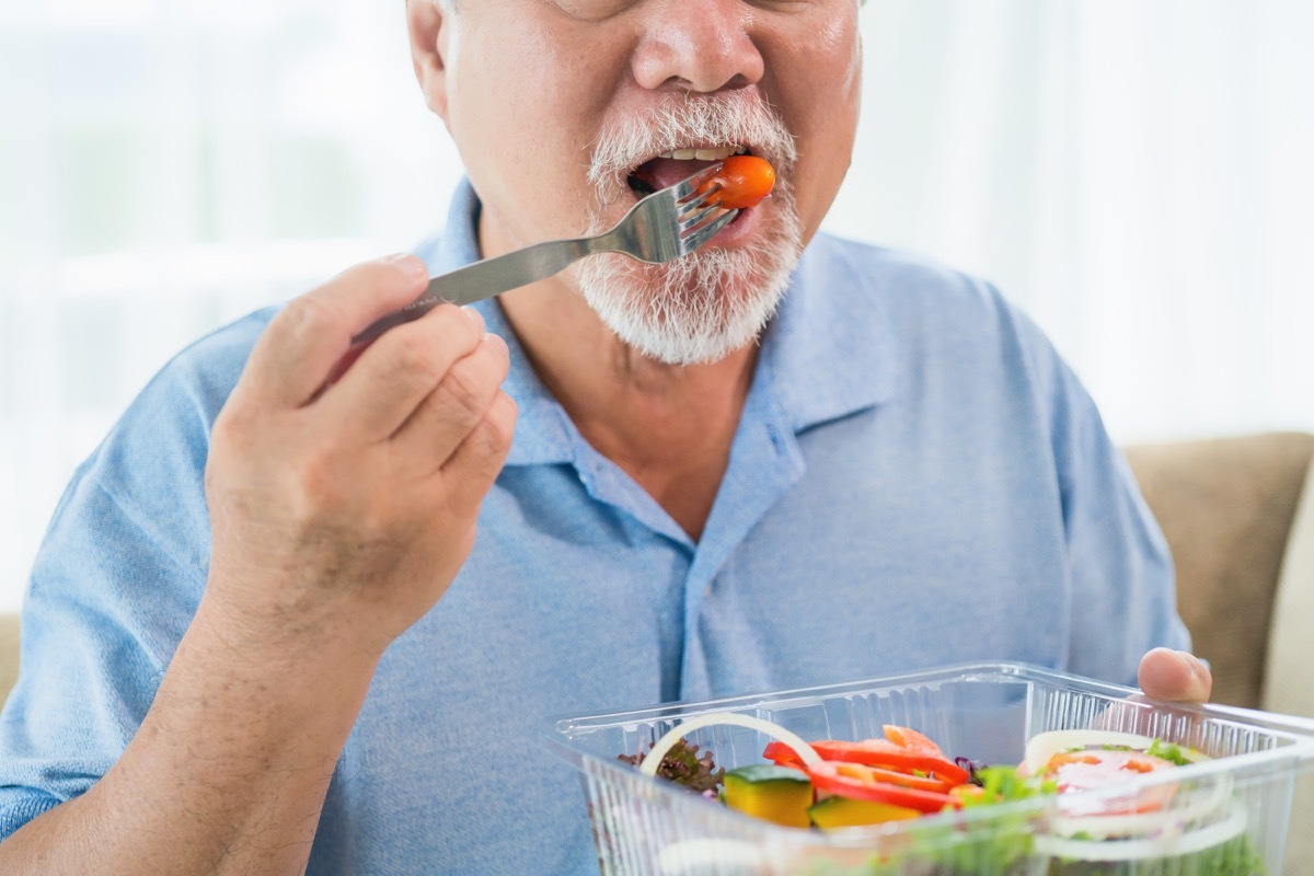 older asian man eating salad