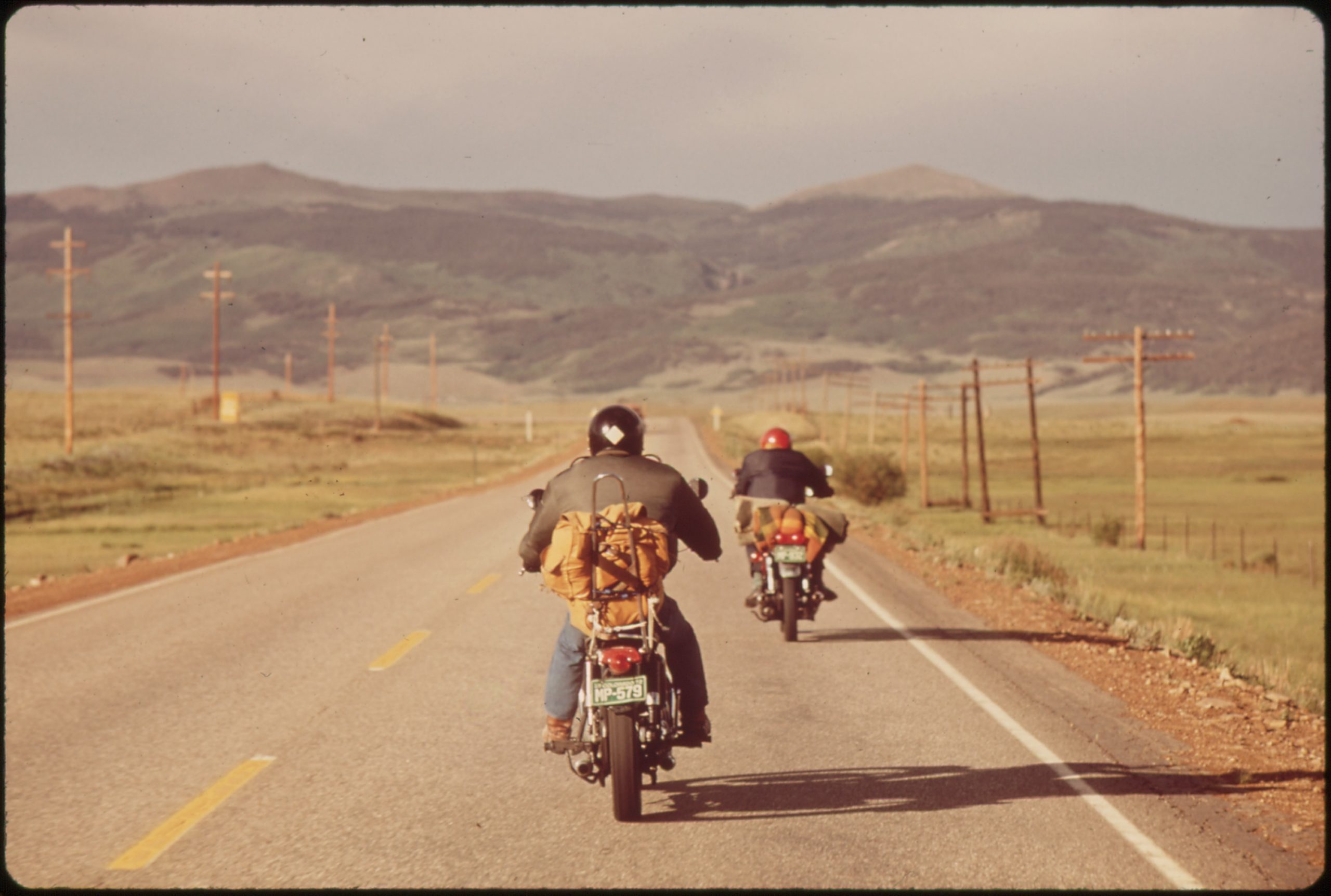 two men ride motorcycles