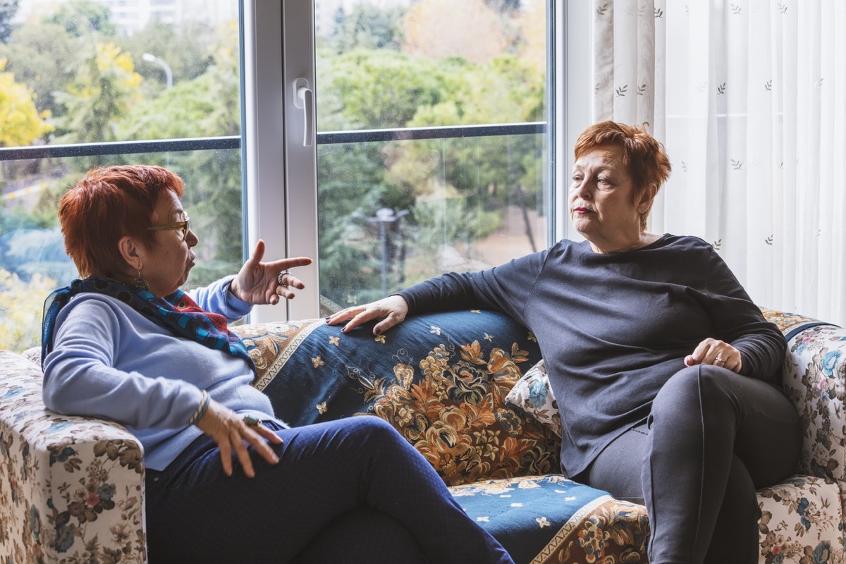 Mature women with short red hair talking on couch