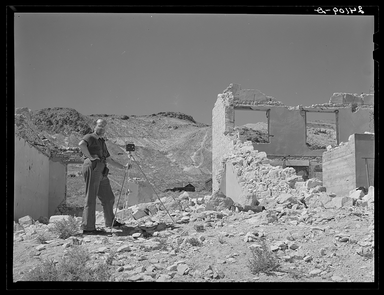 a man takes a photo next to ruins