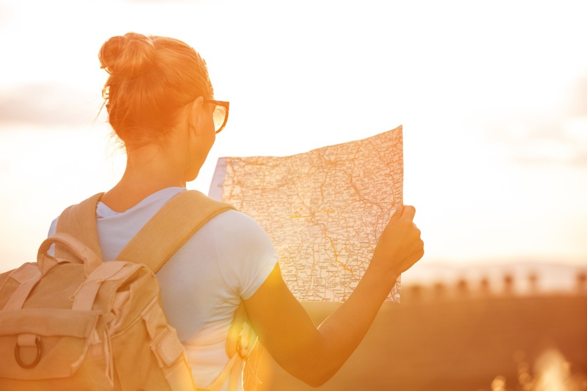 woman wearing a backpack and holding a map