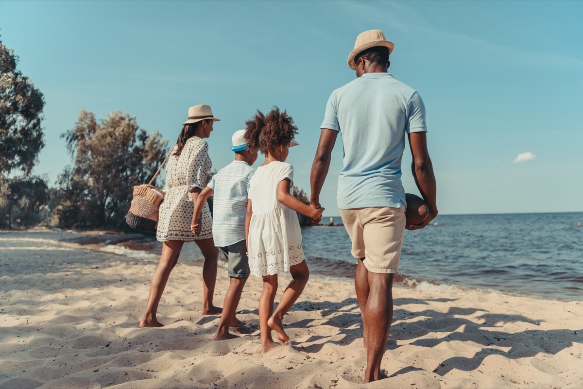 young black family walking on beach