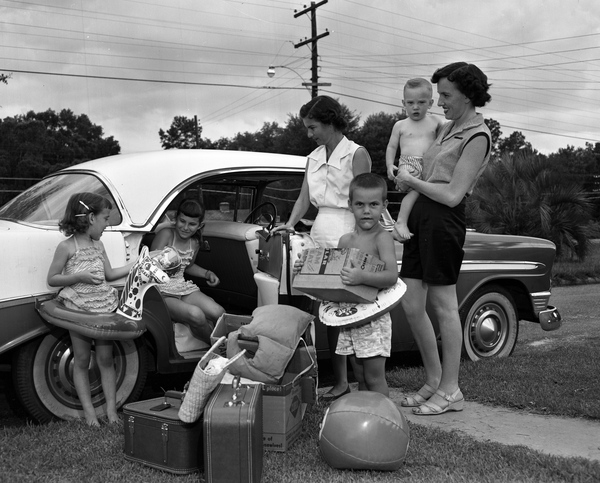 two mothers and four kids get out of a vintage car