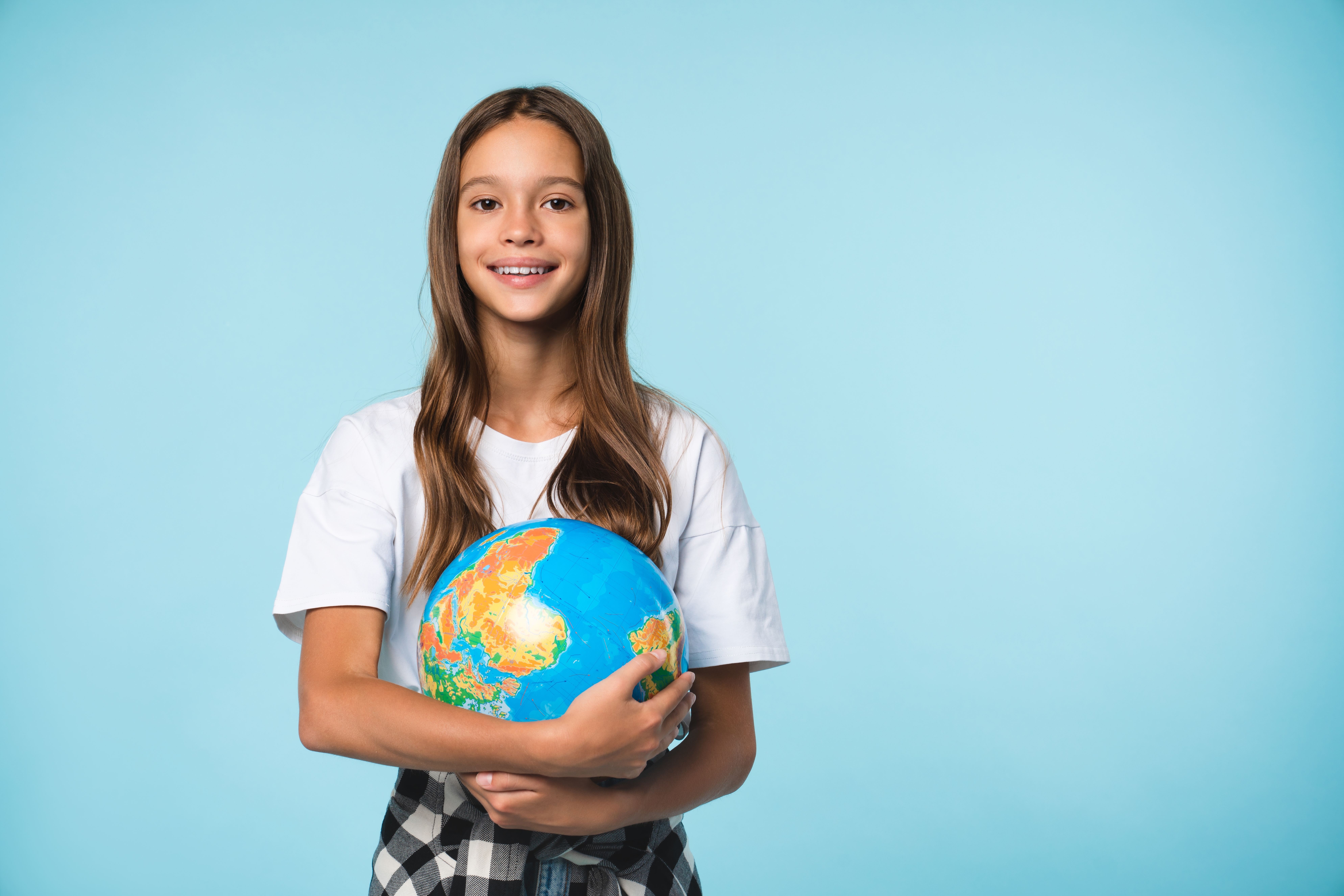 young girl holding a globe practicing geography quiz questions