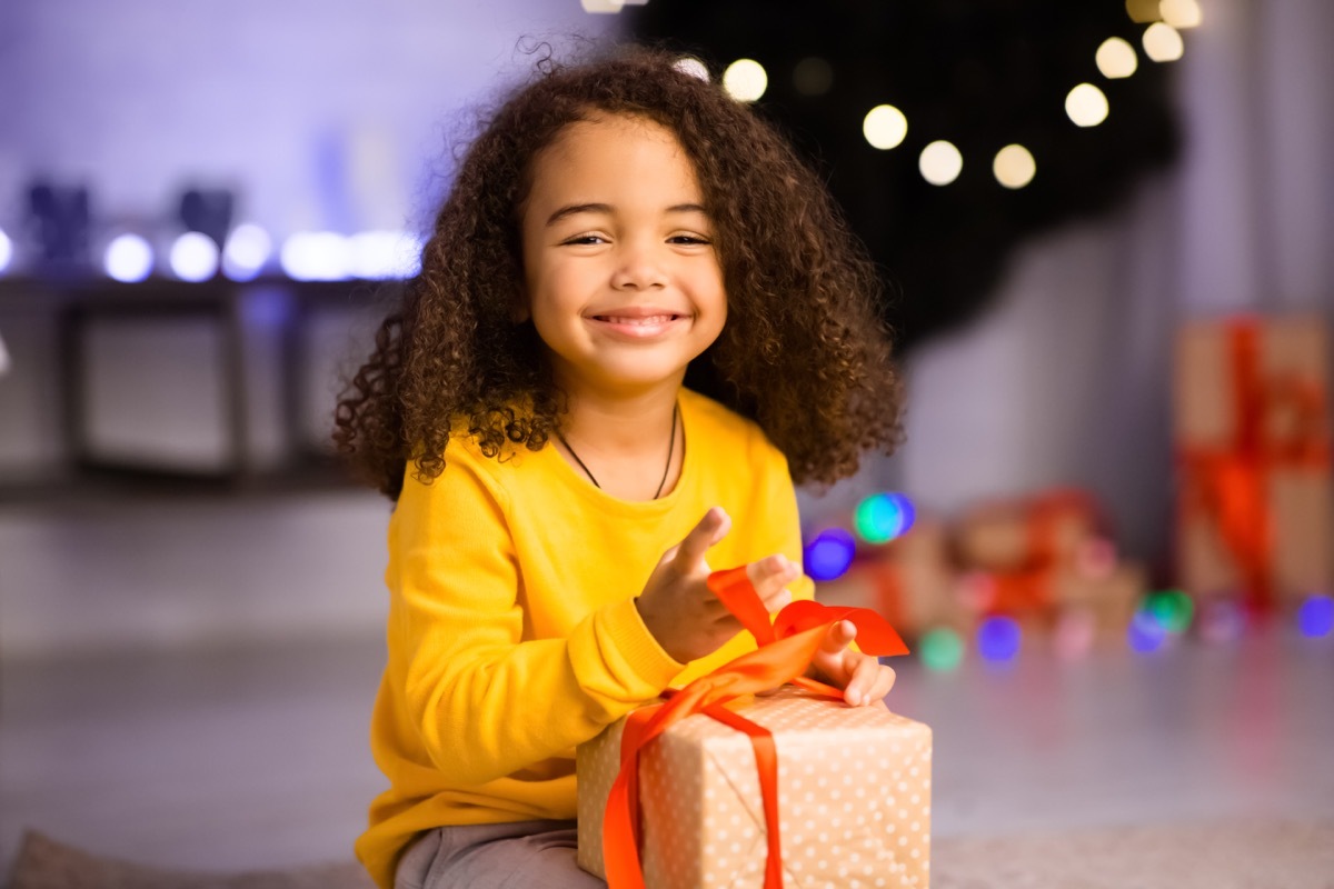 happy little girl opening gift