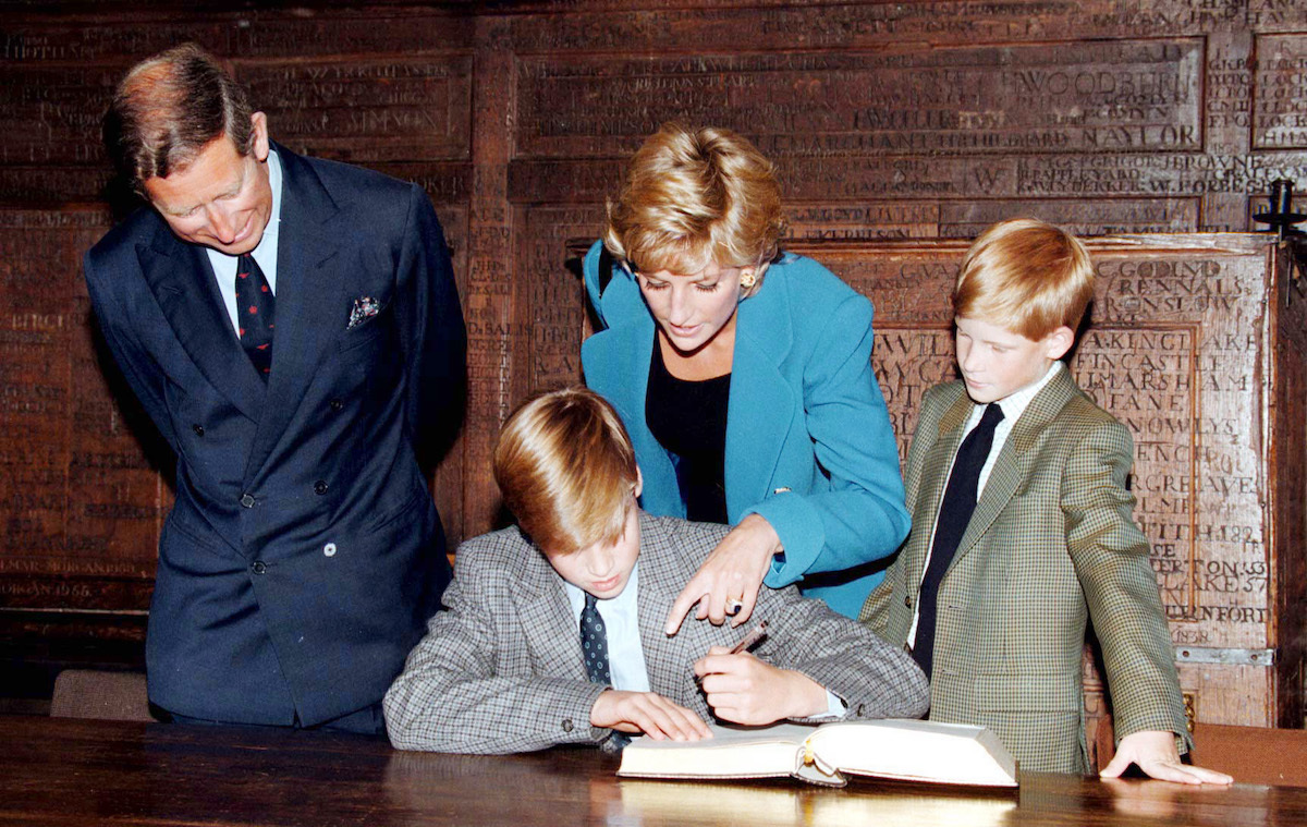 Prince William signs in on his first day at Eton College watched by his parents, he Prince and Princess of Wales and brother, Prince Harry on September 06, 1995 in Windsor, England.