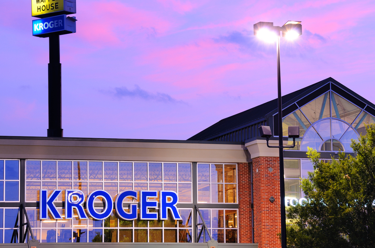 Closeup of a Kroger store at dusk with a purple sky in the background.