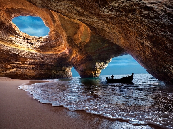 beach underneath a cave with a boat Portugal