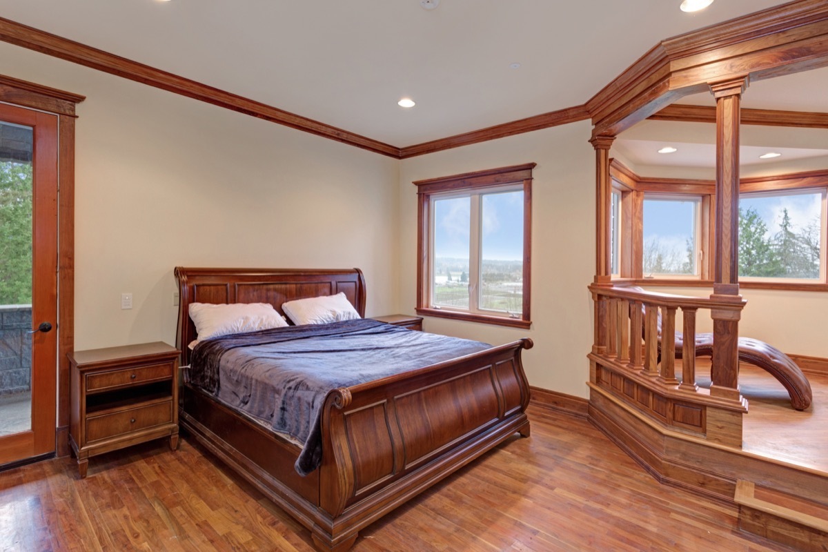 dark wood sleigh bed and chaise in large bedroom