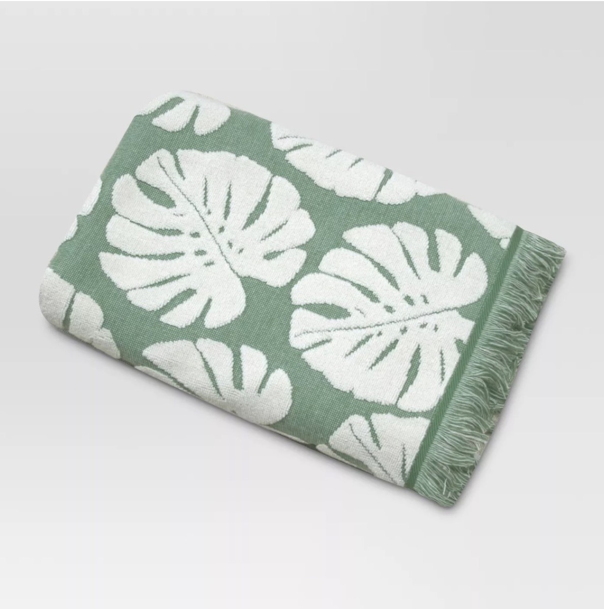 green bath towel with white leaves on it, bathroom accessories