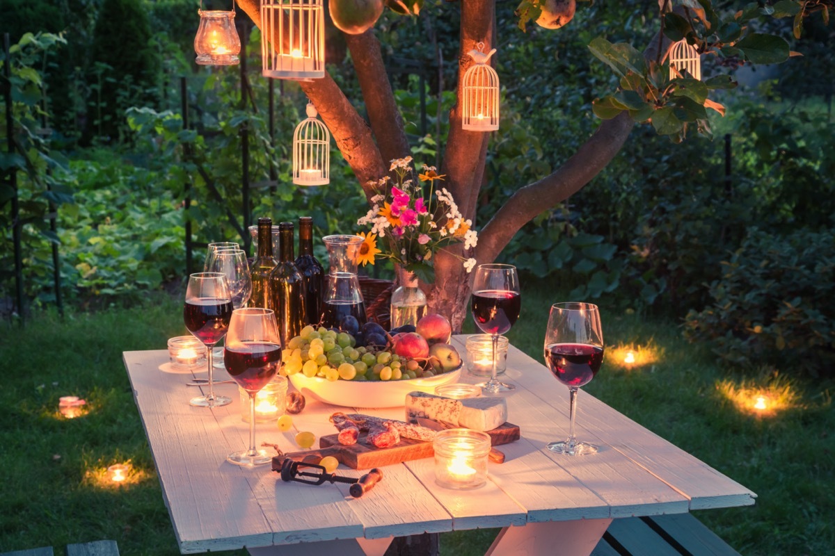 table full of cheese and meats in garden at dusk