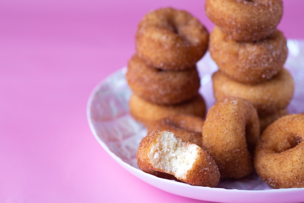 mini doughnuts on white plate with pink background