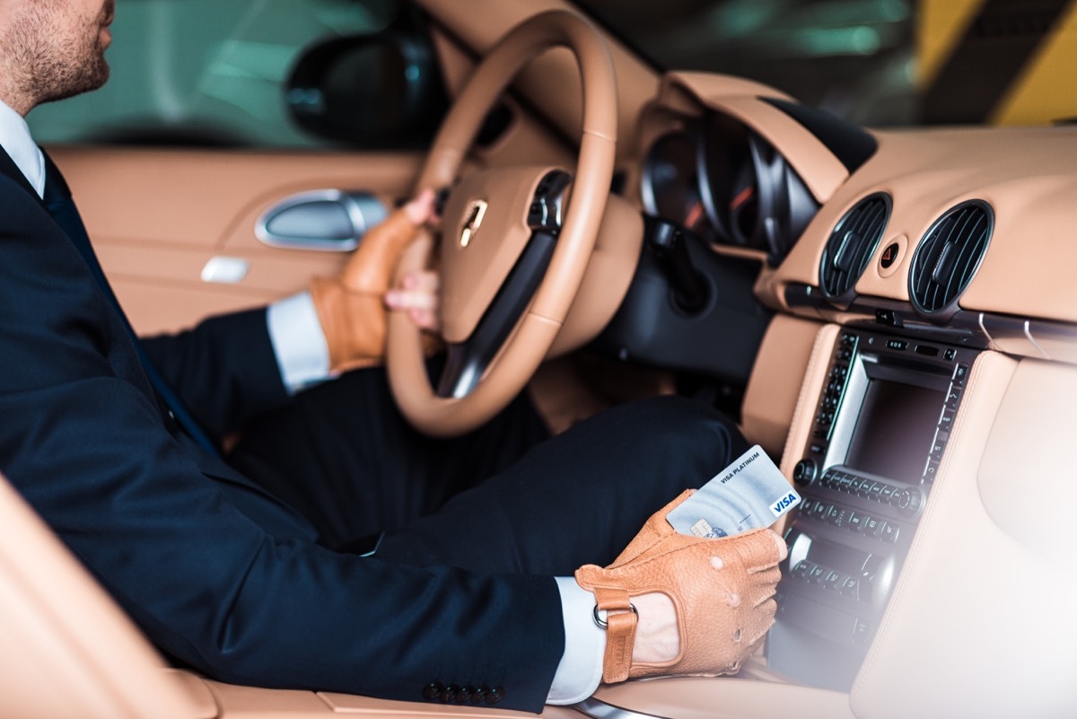 interior shot of a man wearing a suit and sitting behind the wheel of a porsche 911 turbo